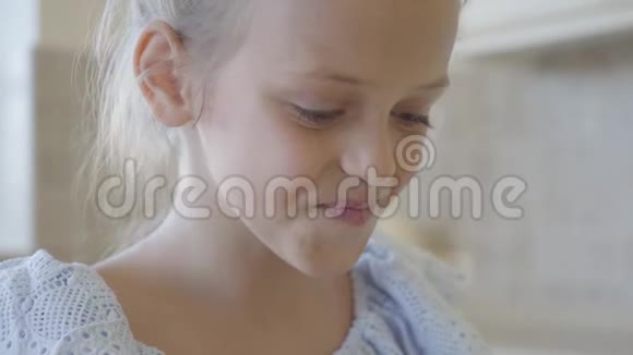 小可爱的女孩咬掉一块馅饼用牛奶喝下去然后看着相机微笑着展示视频的预览图