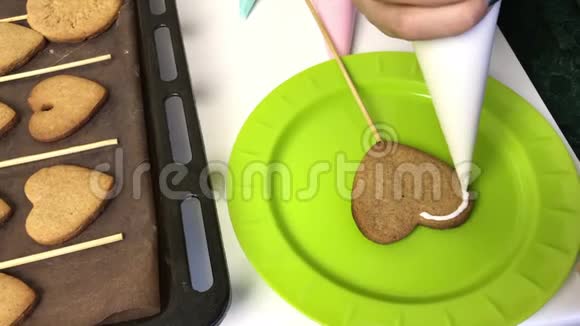 女人在姜饼上涂上糖霜饼干被放置在烤片旁边以便进一步上光视频的预览图