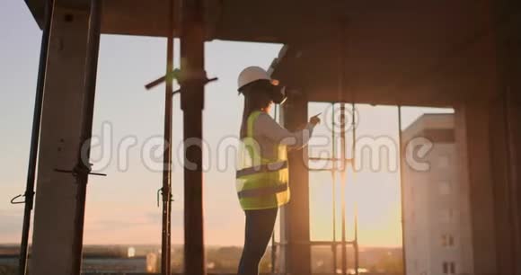一位戴着虚拟现实眼镜的建筑工地女工程师用双手模拟界面的工作视频的预览图