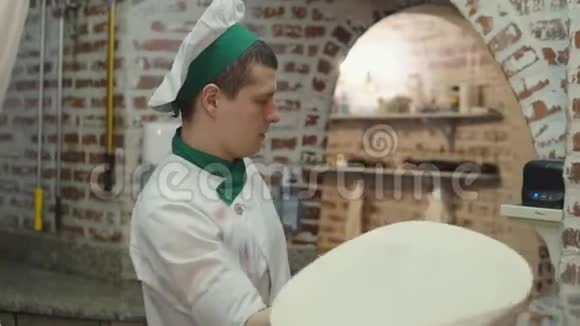 男厨师旋转披萨面团圈视频的预览图