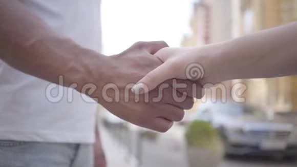 中东男人和高加索女人在城市背景特写面前握手爱情友谊浪漫视频的预览图