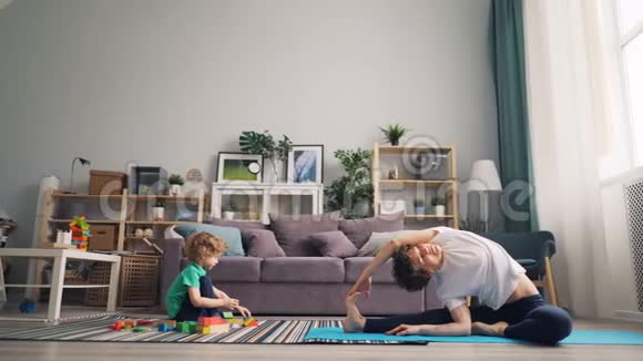 爱妈妈练习瑜伽看着儿子玩砖头说话视频的预览图
