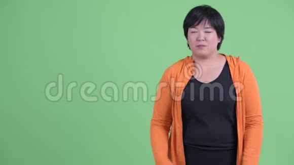 穿着紧身的年轻超重的亚洲女人展示了准备好的健身房视频的预览图