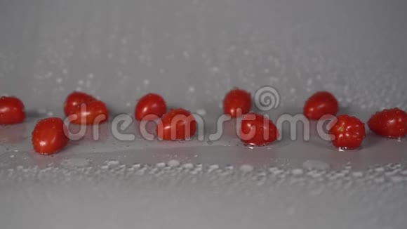 樱桃番茄洗过后水滴从灰色背景的蔬菜中流出视频的预览图