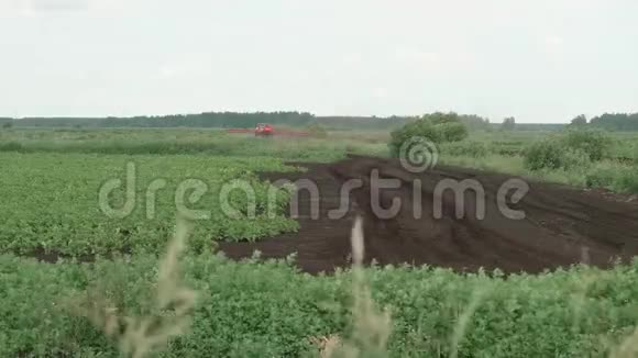 有特殊设备的拖拉机在田间喷洒植物视频的预览图