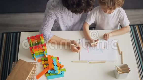 小孩子在家里和细心的妈妈一起画画和涂色视频的预览图