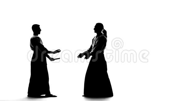两个雄性在基科吉或和服中的黑色细枝末节用坦托表现出合气道孤立无援白人慢动作视频的预览图