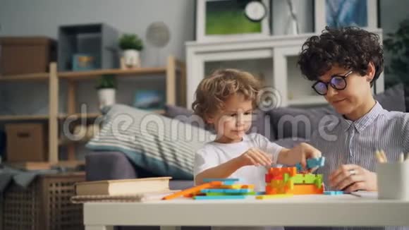 快乐的孩子在家里和妈妈一起玩积木专注于游戏视频的预览图