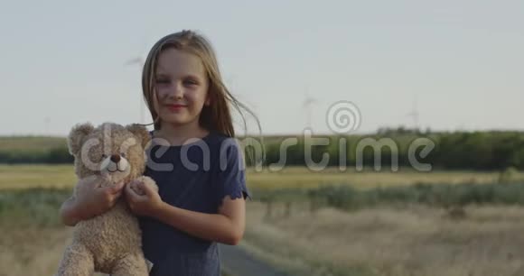 戴着泰迪熊在镜头前摆姿势的女孩视频的预览图