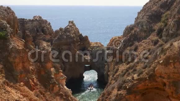 在葡萄牙拉各斯一艘带游客的船在探索了它迷人的岩层之后离开了PontadaPiedade视频的预览图