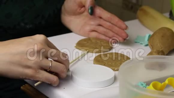 女人正在准备姜饼在她面前是一根棍子上的饼干切割机烘焙饼干堆放在旁边视频的预览图
