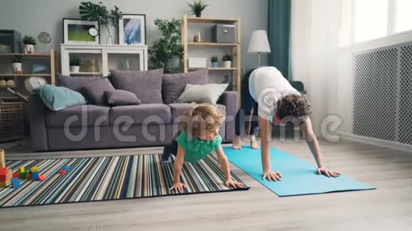 妈妈和小儿子一起在家做瑜伽放松享受活动视频的预览图