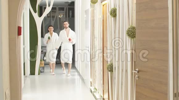 两个情人沿着走廊去温泉疗养健康生活方式视频的预览图