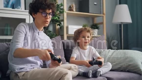 幸福的家庭母子在公寓里玩电子游戏一起玩视频的预览图