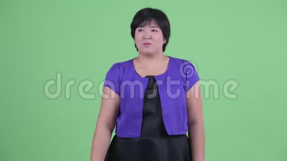 快乐的年轻超重的亚洲女人手指着看上去很惊讶视频的预览图