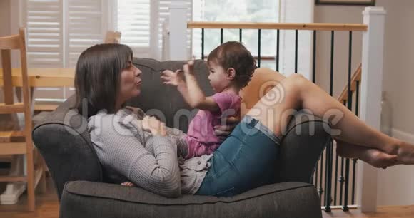 妈妈和女婴一起在沙发上玩耍视频的预览图