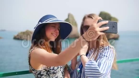 两个年轻的女人在大海的背景下通过电话拍照视频的预览图