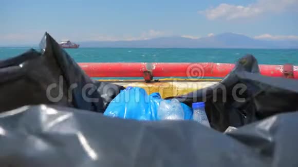 塑料垃圾装在船上的袋子里从海上的塑料在海景背景上在地平线上航行视频的预览图