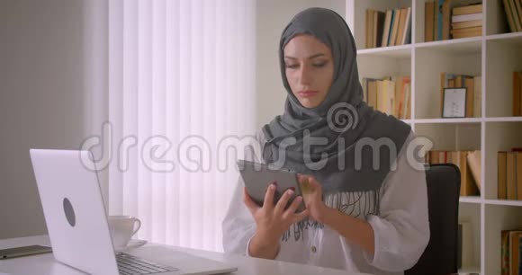 年轻迷人的穆斯林女商人头巾特写照片使用平板电脑并显示绿色彩色屏幕视频的预览图