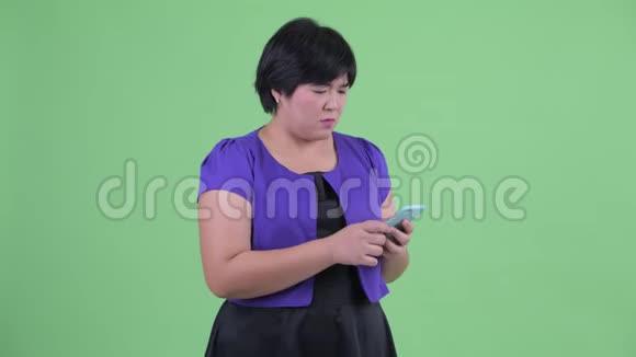年轻体重超标的亚洲女人用电话接坏消息视频的预览图