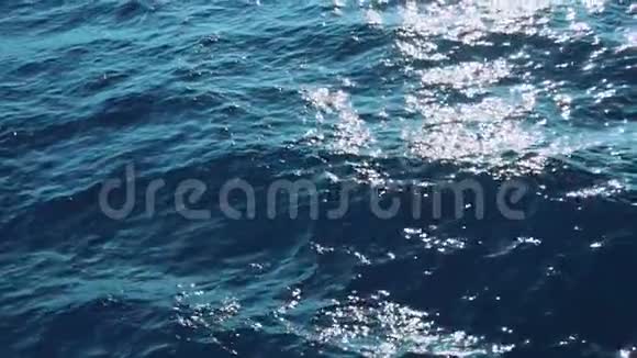 慢点莫美丽的阳光照耀下的蓝色海浪真正的水波荡漾在海面上关闭液态纹理表面视频的预览图