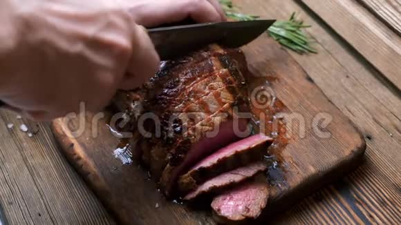 厨师用老式刀切烤牛肉牛排在乡村砧板上视频的预览图