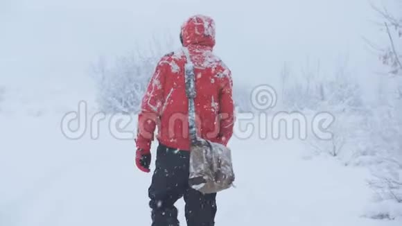 一个男性旅行者在大雪中行走试图出去从后面看到的视频的预览图