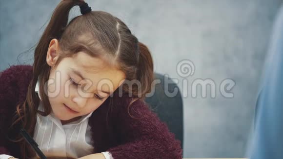 一个灰色背景的女孩写作业在这期间妈妈会吵架挥舞拳头视频的预览图