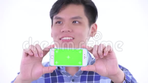 一个快乐的年轻亚洲时髦男人一边看手机一边思考视频的预览图