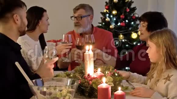 圣诞快乐幸福的一家人正在家里吃晚饭庆祝节日和相聚在树旁视频的预览图