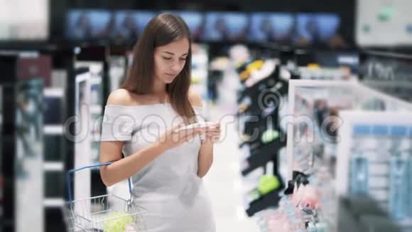 美丽的女孩在化妆品店购物接电话慢动作视频的预览图