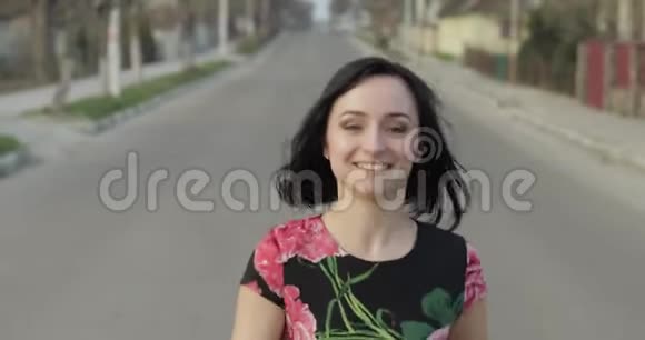 一位漂亮的年轻女子穿着一件连衣裙带着鲜花走向镜头微笑着视频的预览图