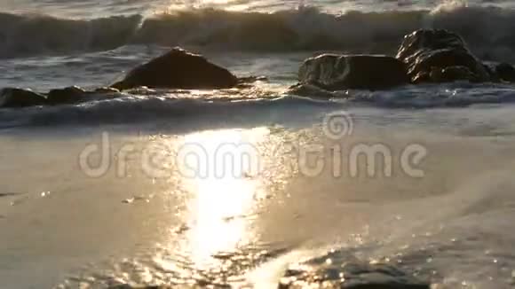 海上日出宁静海景美丽的大浪泡沫覆盖着巨大的岩石和巨石视频的预览图