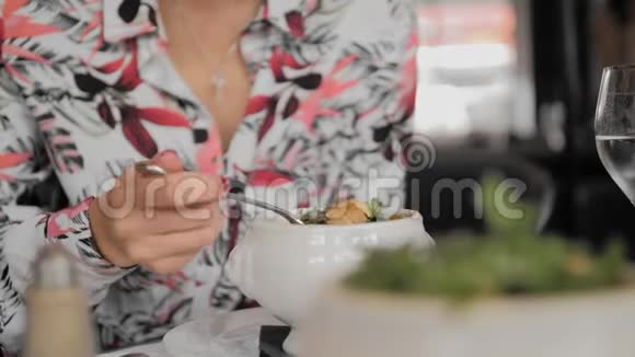 未被识别的女性游客在巴黎的一家餐馆里吃传统的汤汤中有面包融化的奶酪和绿色手视频的预览图