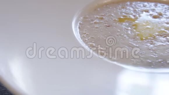 一盘加黄油的粥餐厅餐盘燕麦片关门摄像机绕着这个向右移动视频的预览图