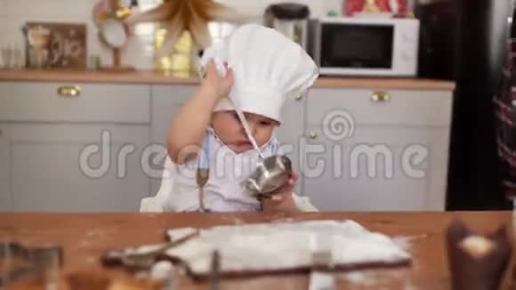 妈妈把厨师帽子戴在她可爱的宝宝身上但孩子把帽子摘下来了视频的预览图