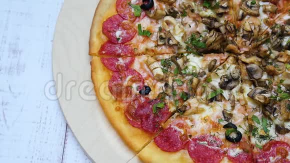 带有意大利香肠特写的披萨放在木桌上男人的手拿一片披萨慢动作视频的预览图