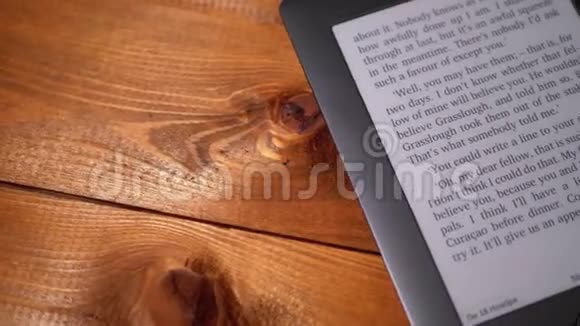 这本电子书躺在一张木桌上电子墨水屏幕显示书籍文本视频的预览图