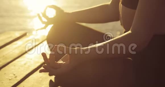 女人日落时分在码头上沉思时她的手在纳马斯特泥沼中摆姿势视频的预览图