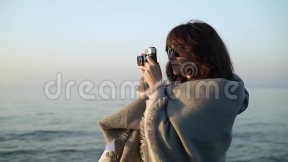 穿灰色衣服的年轻女子拍海洋照片动作缓慢视频的预览图