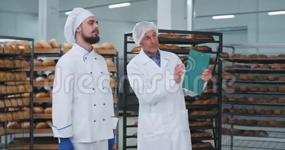面包师和一个面包店的老食品工程师的谈话他们聊天工程师向他们解释一些事情视频的预览图