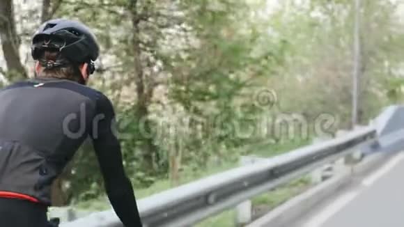 骑自行车的人穿着黑色和红色的衣服骑自行车在公园里后关跟进射击自行车的概念视频的预览图