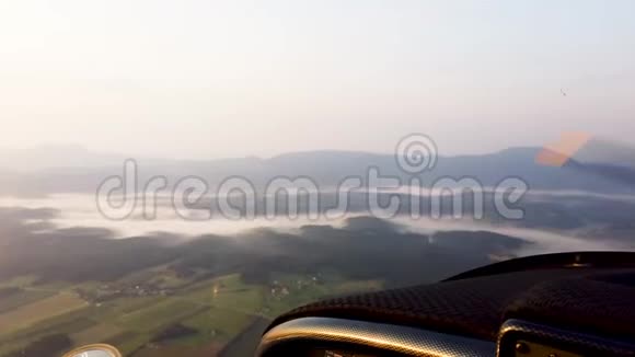 从小型螺旋桨飞机驾驶舱俯瞰雾蒙蒙的景色视频的预览图
