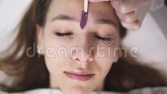 客户躺在沙发上在工作室美容的眉毛治疗期间美容师在视频的预览图