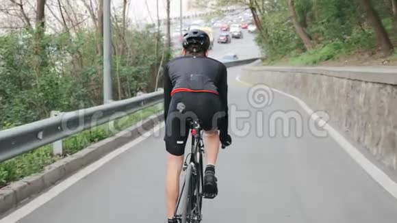 骑自行车的人穿着黑色运动服朝繁忙的城市道路走去自行车的概念慢动作视频的预览图