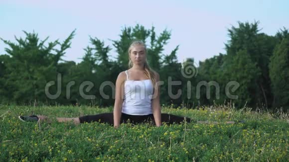 穿着衬衫的年轻女孩在山上用绿草做运动视频的预览图
