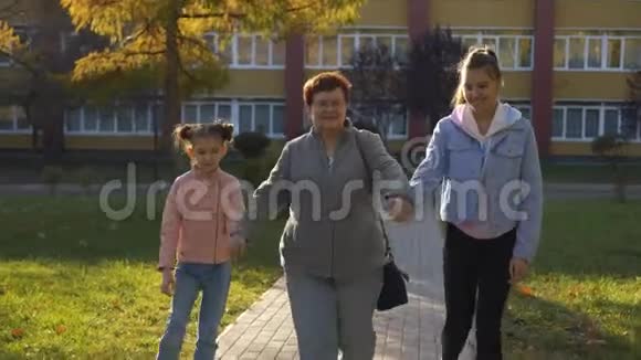 祖母和两个孙女在日落时在公园散步视频的预览图
