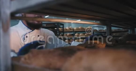 面包店厨房主面包师开心地从货架上拿一些新鲜面包闻起来很深很高兴地走了食物视频的预览图