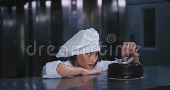 这位年轻漂亮的女士穿着全副厨师的服装嘴里放着红色的樱桃看上去视频的预览图