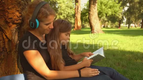 那孩子读这本书而她的母亲听音乐视频的预览图